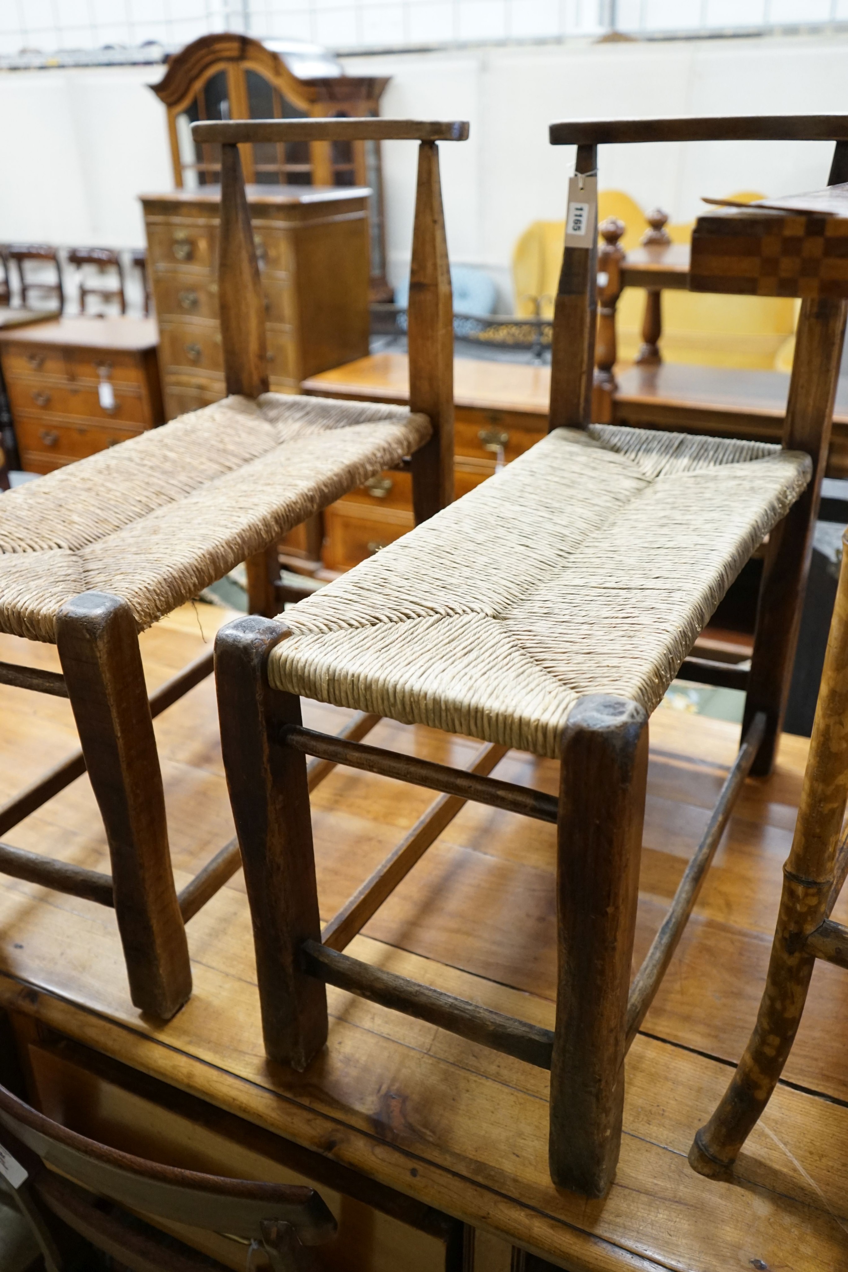 A pair of French provincial oak and beech stools with elongated rush seats, width 31cm, length 67cm, height 73cm